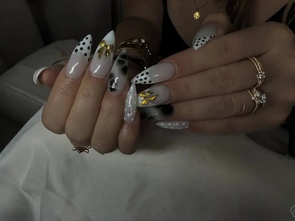 Nail art pois noir et blanc, nœuds dorés